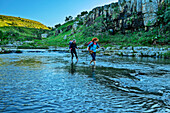  Two women hiking wade through a river, Wild Coast Trail, Wild Coast, Eastern Cape, South Africa 