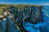  Man and woman hiking looking at waterfall of Mfihlelo River, Wild Coast Trail, Wild Coast, Eastern Cape, South Africa 