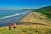  Two people walking towards the sandy beach of Ntlupeni Bay on the Indian Ocean, Wild Coast Trail, Wild Coast, Eastern Cape, South Africa 
