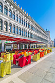  Colorful covers and seating in front of cafes on St. Mark&#39;s Square, Venice, Italy 