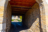 City Street with House and Tunnel and a Water Fountain in a Medieval Old Town in a Sunny Summer Day in Regensberg, Zurich Canton, Switzerland.