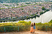 Two young women admiring the city of Cahors from the viewpoint at Mont Saint Cyr, Lot department, region of Midi-Pyrenees, Occitanie, southwest of France, Europe