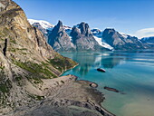 Luftaufnahme des Expeditionskreuzfahrtschiffs World Voyager (Atlas Ocean Voyages) mit Gletscherabfluss im Vordergrund und Bergen dahinter, Evighedsfjorden (Ewigkeitsfjord), Queqatta, Grönland, Europa