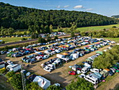 Aerial of tents and vehicles parked on meadow as part of Haune-Rock 2025 music festival, Haunetal Odensachsen, Hesse, Germany