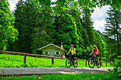 Mann und Frau beim Mountainbiken fahren an Forsthaus vorbei, Mangfallgebirge, Bayerische Alpen Oberbayern, Bayern, Deutschland