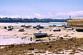 Fishing boats in the mud at low tide at the Mole des Noires in front of the fortified island of Ville Close in Saint-Malo, Côte d'Emeraude, Côtes-d'Armor, Brittany, France