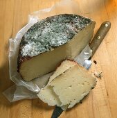 Pecorino Cheese Partially Sliced on Wax Paper