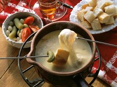 Skewers with bread & mixed pickles above cheese fondue