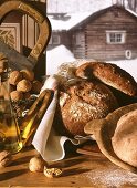 Stillleben mit Bauernbroten,Nüssen,Öl vor Fenster im Winter