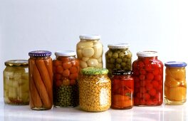 Various preserving jars with vegetables, fruit, sausages