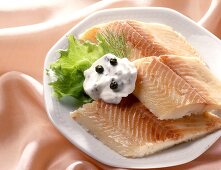 Smoked trout fillets with yoghurt & caper dip on plate