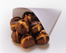 Roasted chestnuts falling out of a paper bag
