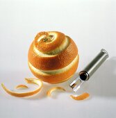 Orangenschale spiralförmig mit Schäler geschnitten