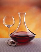 Carafe, empty red wine glass & corkscrew beside it