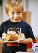 Small boy holding plate with apple cake