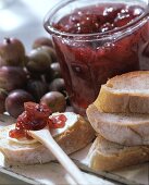 Stachelbeermarmelade im Glas und auf Butterbrot