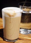 Latte Macchiato, dahinter ein Glas Wasser