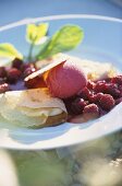 Crepe mit einer Kugel Himbeer-Cassis-Eis und Himbeersauce