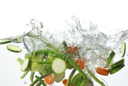 Fresh vegetables falling into water