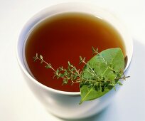 Fish stock in a bowl with bay leaf and thyme