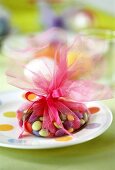 Coloured chocolate beans packed in tulle as Easter gift