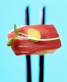 Nigiri-sushi with tuna on chopsticks