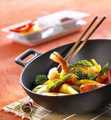 Wok with vegetables and shrimps, chopsticks