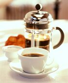 Tasse Kaffee, dahinter eine Cafetière