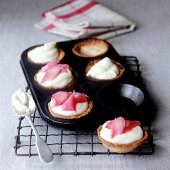 Tartlets with rhubarb cream filling in a baking tin