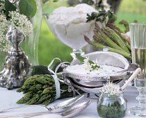 Herb quark in silver bowl and green asparagus