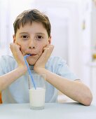 Junge trinkt Milch mit Strohhalm