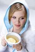 Young woman holding bowl of lemon tea