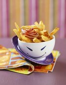 A bowl of chips with ketchup & mayonnaise for kid's party