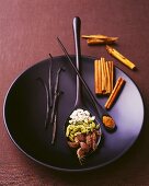 Still life with spices on a black plate