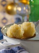 Thuringian dumplings on ladle at edge of pan