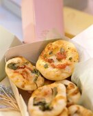 Mini-pizzas with tomatoes and herbs in a box