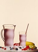 Ice-cooled berry shake in glass and jug