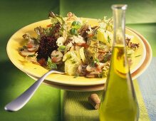 Salad leaves in tomato vinaigrette with mushrooms; olive oil