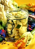 Courgettes and cauliflower in vinegar in pickling jar