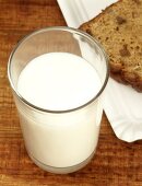 A glass of milk beside a slice of bread