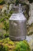 Milk can on stone wall