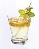 Kumquat punch with skewered exotic fruit in glass