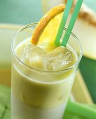 Honeydew melon drink with avocado, ice cubes & orange slice