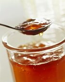 Apple jelly in jar and on spoon