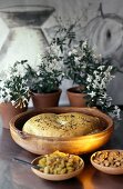 Middle Eastern flatbread in terracotta pot; raisins; almonds