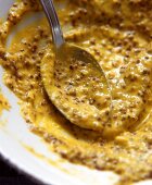 Dijon mustard on plate and spoon (close-up)