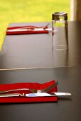 Einfach gedeckter Tisch mit Besteck und roten Servietten