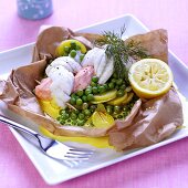 Fish with saffron sauce, peas and potatoes in baking paper