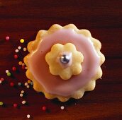 A pink sweet pastry flower with sugar pearls