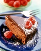 A piece of moist chocolate cake with raspberries